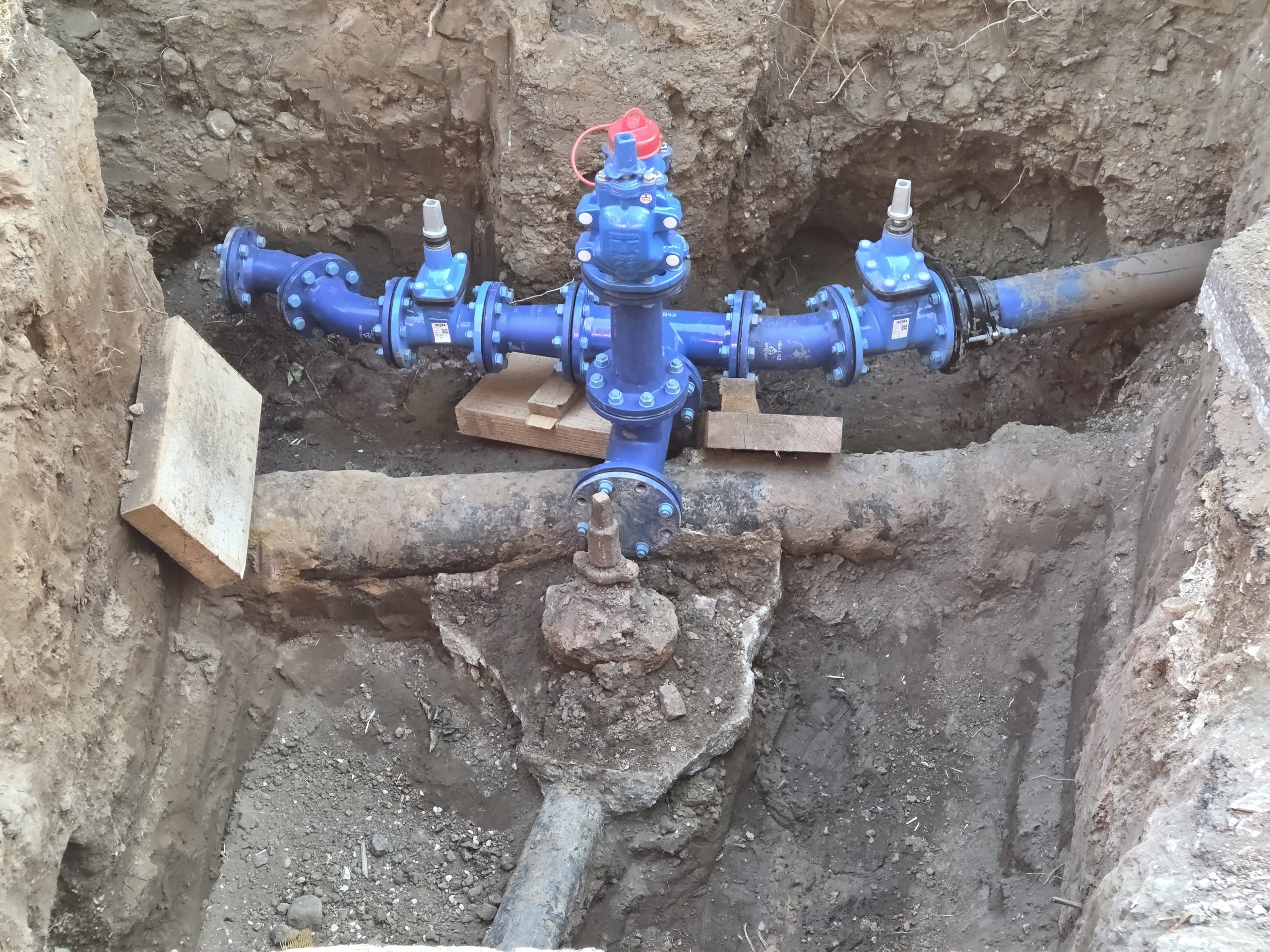 View of a hole in the ground with exposed water pipe